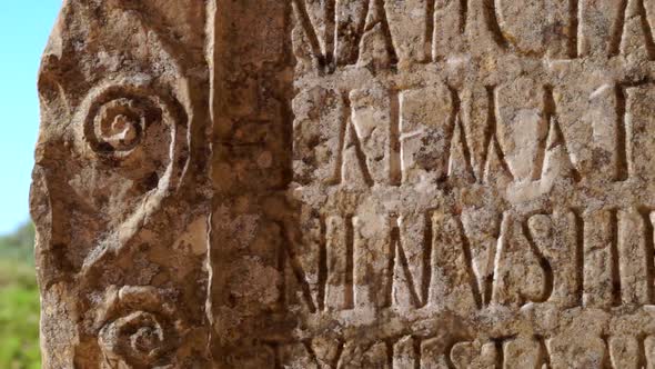 Tight shot of carved words in stone panel at ancient Roman ruins at the archaelogical UNESCO Heritag