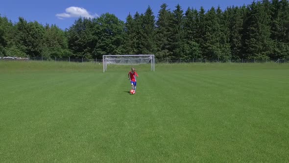 Slow motion shot of a young boy playing soccer on a soccer field