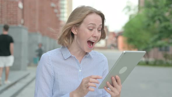 Portrait of Woman Celebrating on Tablet While Walking in Street