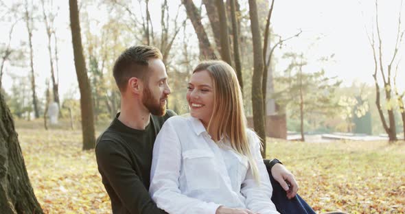 Happy Lovely Couple Having Relax in Embraces on Park Bench They Rejoicing