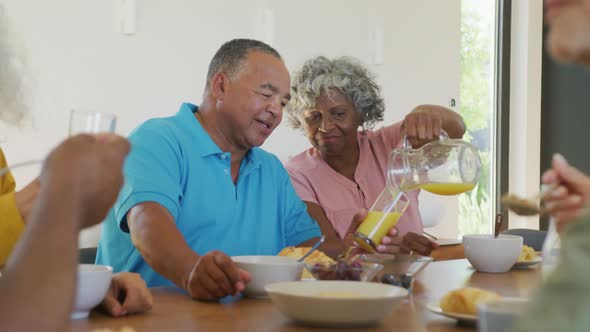 Happy senior diverse people having breakfast at retirement home