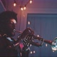A young man listening to music with headphones and playing the trumpet with red neon light - VideoHive Item for Sale