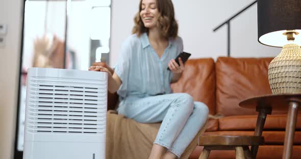 Woman with Air Purifier or Conditioner at Home