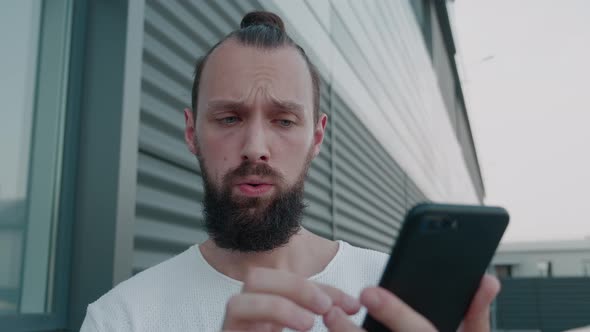 Surprised Man Looking in Smartphone