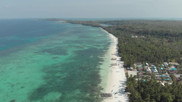 Aerial: flying over white sand beach tropical sea Kei Islands Maluku Indonesia