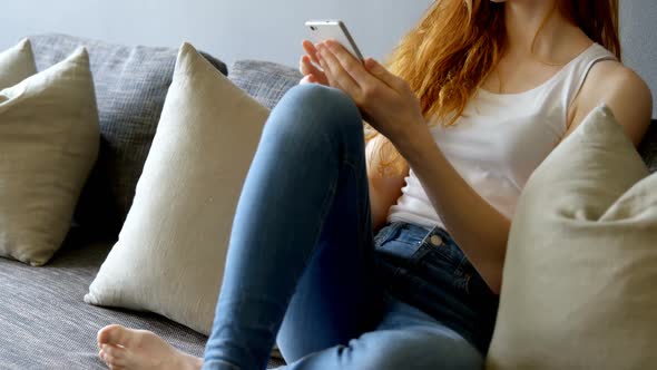 Woman using mobile phone in living room 4k