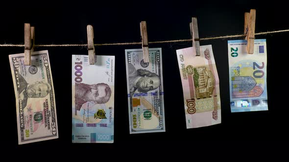 Banknotes of Different Countries Dry on a Clothespin Rope
