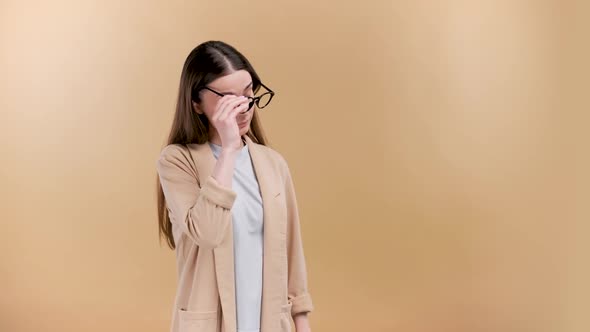 Young Entepreneur Taking Off Glasses with Tiredness and Exhaustion Emotion on Beige Background