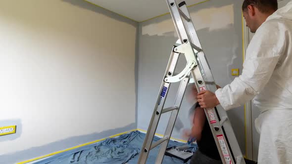 time-lapse with camera panning slowly right as couple redecorate and paint room together