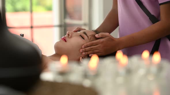 Young beautiful asian woman enjoys massage in a luxury spa resort