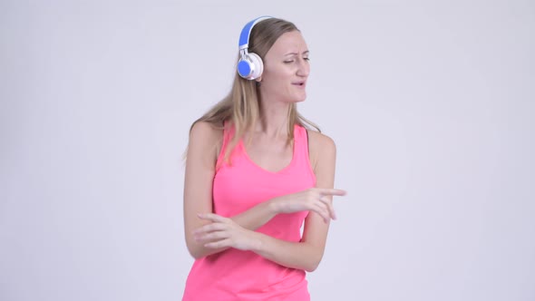 Portrait of Happy Blonde Woman Listening To Music and Dancing