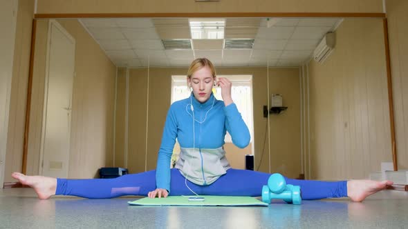 Young Woman in Earphones While Stretching to Calm Music