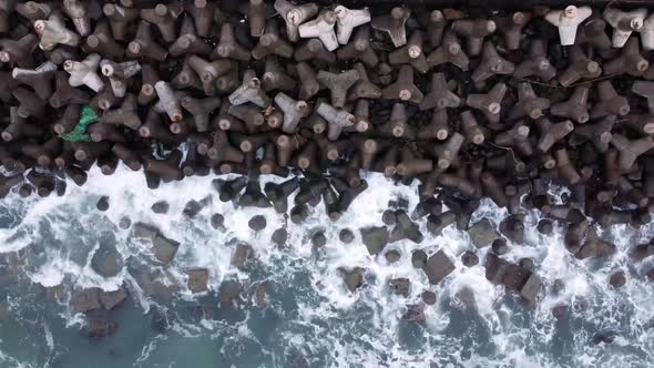Aerial view of sea wave crashing tetra concrete block or wave breaker stone at Glagah beach, Indones