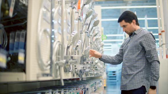 Man in the Store Choosing Shower Head for Bathroom Renovation