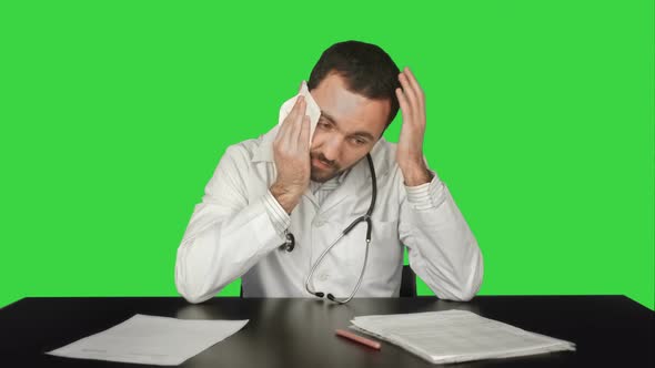 Aggressive Disappointed Doctor at a Table on a Green Screen, Chroma Key