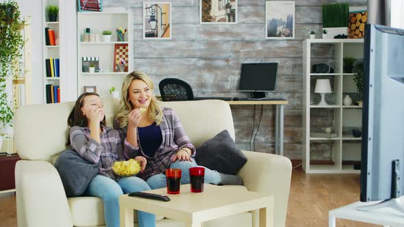 Cheerful Mother and Daughter Sitting on the Couch