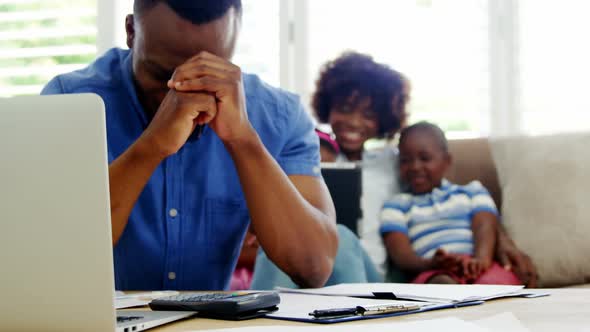 Worried man sitting with bills