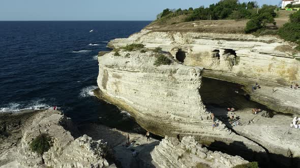 Rocks in The Sea And People Standing On It 