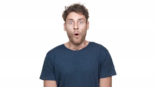 Portrait of Shocked European Guy in Tshirt Looking on Camera and Expressing Surprise with Open Mouth