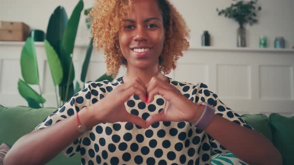 Young African American Woman Shows Heart Gesture Demonstrating Romantic Mood