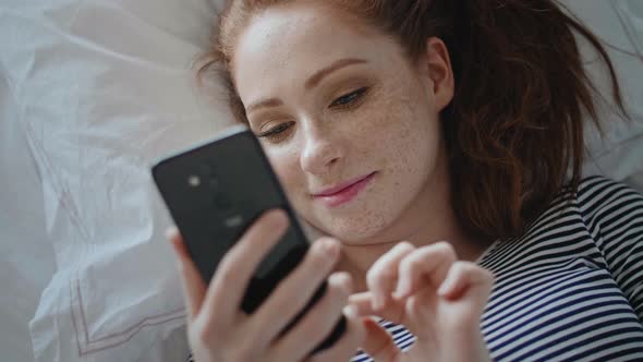 Top view of young woman browsing a phone