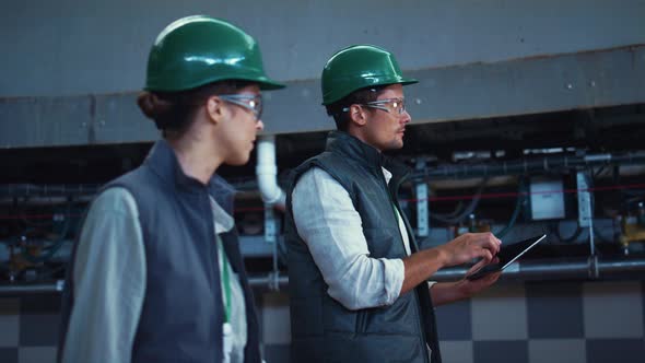 Agriculture Supervisors Inspecting Manufacture Facility Together in Uniform