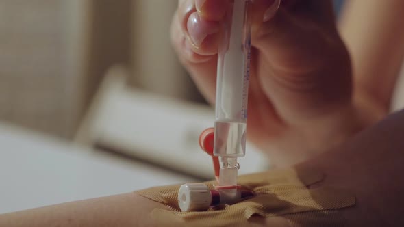 Young Woman Alone at Home Injects Medicine From a Syringe Into a Vein