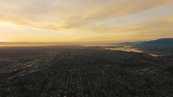 Golden sunset over sprawling west coast metropolis, Vancouver, B.C.; aerial