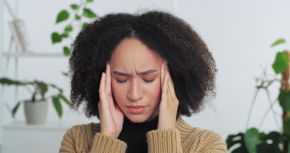 Portrait of Female Sad Face Afro American Woman with Curly Hair Suffering From Headache Massaging