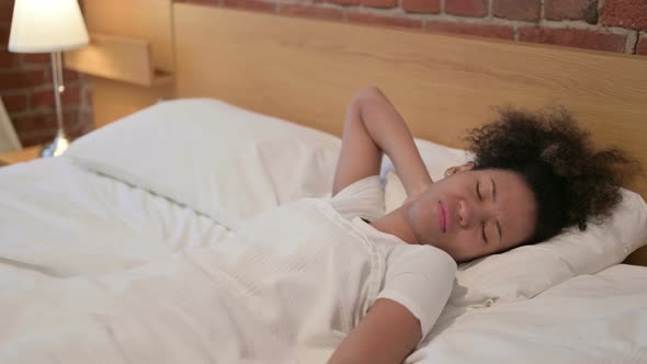 African Woman Having Neck Pain While Sleeping in Bed