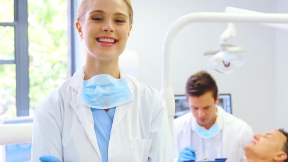 Portrait of smiling dentist standing with arms crossed