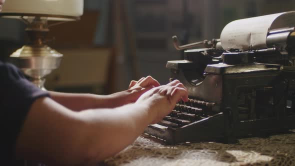 Hands Writing on Old Typewriter Over Wooden Table Background