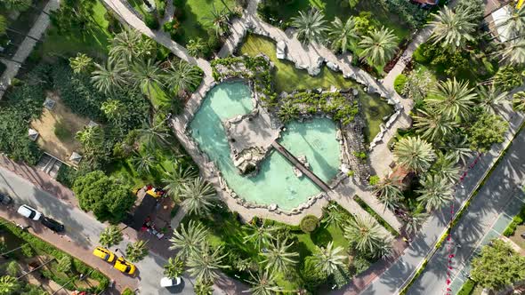 Fountain in the park around the palm trees 4 K