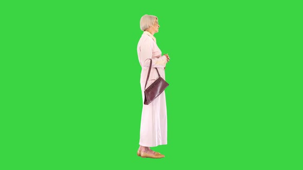 Old Woman Lady in Pink Dress Standing and Waiting on a Green Screen Chroma Key