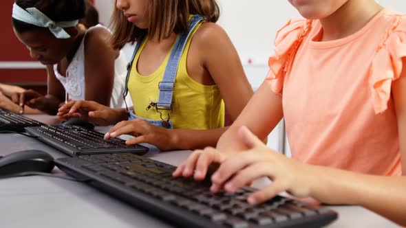 Schoolgirls using computer in classroom