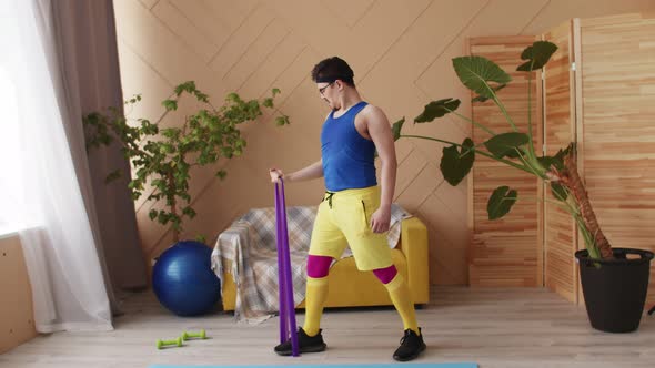 Fitness man with a moustache, glasses and headband in blue, yellow and purple retro sportswear doing