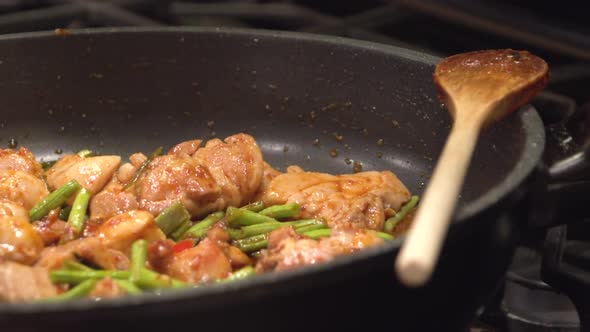 Cooking Thai food, Gai Pad Prick Gaeng, in a hot frying pan.