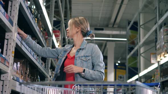 Supermarket with a Woman Taking Packets of Groceries