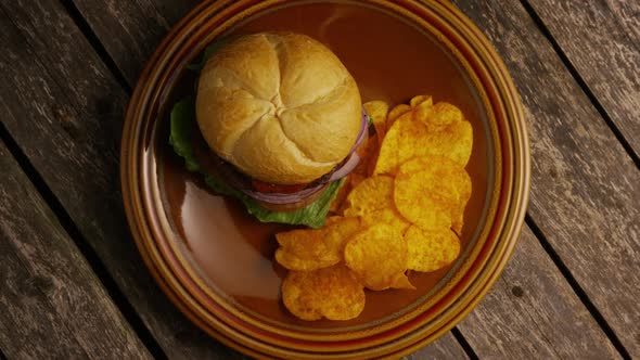 Rotating shot of delicious burger and potato chips 