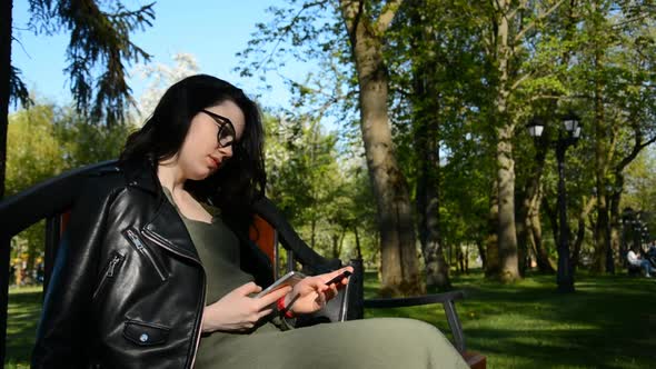 Portrait of a Happy Woman Paying Online with Credit Card and Smart Phone in a Summer Park