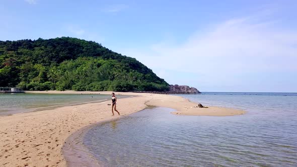 Young Pretty Woman in Black Swimsuit Running Alone on a SandbarThailand