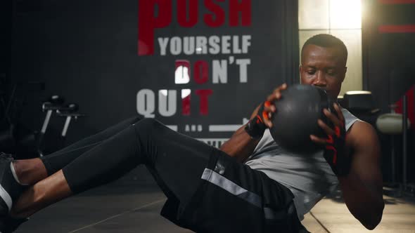 4K African man athlete do weight training exercise with medicine ball at gym.