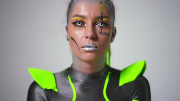 Headshot Portrait of Confident Young Woman with Bright Makeup and Zombie Contact Lenses Looking at