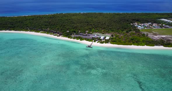 Luxury birds eye travel shot of a white paradise beach and aqua blue ocean background in vibrant 4K