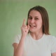 Angry Woman Wags Finger to Somebody Posing at Green Wall - VideoHive Item for Sale
