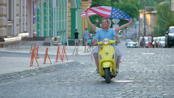 Couple Riding Scooter and Smiling.