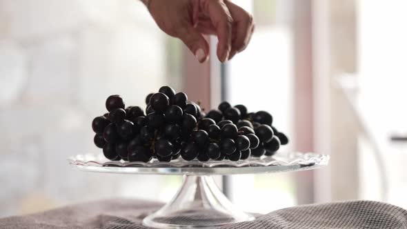 Closeup Delicious Grape in Transparent Tray with Female Hand Taking One Berry in Slow Motion Leaving