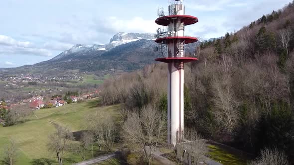 Drone shoting in on an Antenna with Villages and Mountains in the background