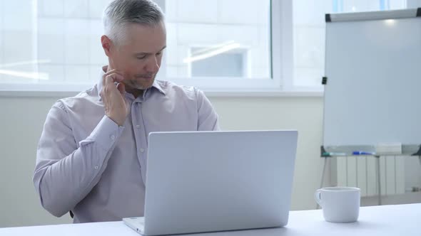 Tired Middle Aged Businessman with Neck Pain Working in Office