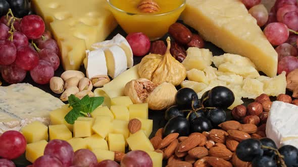 Cheese plate. Assortment of spanish or italian antipasti snack with cheese, nuts, bread, grapes, dat